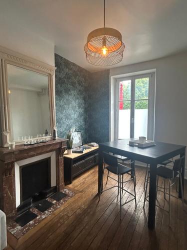 une salle à manger avec une table bleue et un miroir dans l'établissement Chez Léa-Magnifique maison au centre-ville, à Chaumont