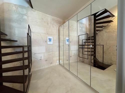 - un escalier dans une pièce aux murs en verre dans l'établissement Maison Cosy avec rooftop et BBQ - Roquette, à Arles