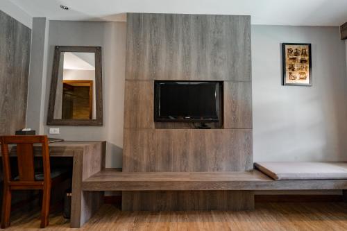 a living room with a flat screen tv and a couch at Naiya Buree Boutique Resort Nai Harn Beach in Rawai Beach