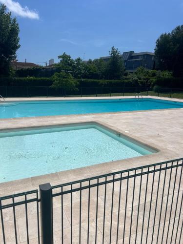 une grande piscine entourée d'une clôture. dans l'établissement Les Jardin de la mer, à Antibes