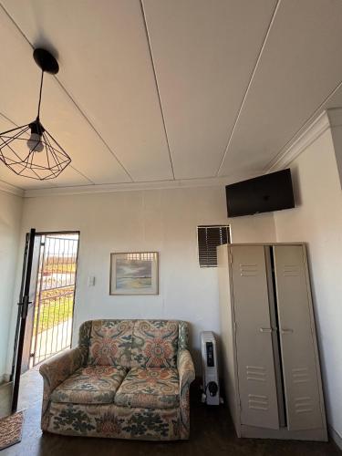 a living room with a couch in a room at Dewdrop Farm Stay in Ermelo