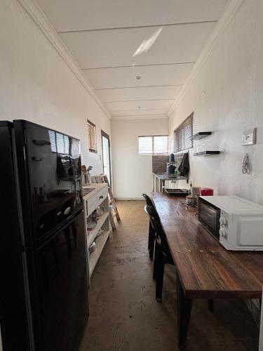 a kitchen with a wooden table and a refrigerator at Dewdrop Farm Stay in Ermelo