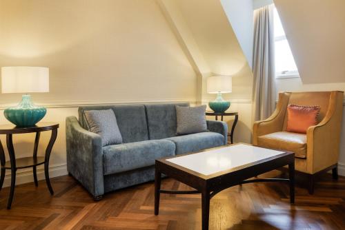 a living room with a couch and two chairs at The Caledonian Edinburgh, Curio Collection by Hilton in Edinburgh