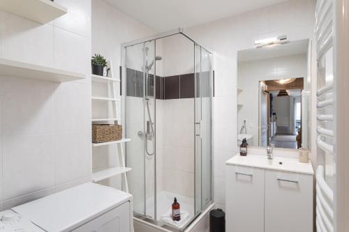 une salle de bain blanche avec une douche et un lavabo dans l'établissement Kerlibri - 15min à Pied de la Plage, à Dinard