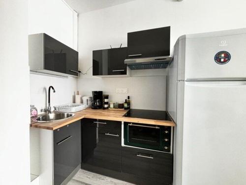 Una pequeña cocina con nevera y fregadero. en Joli studio hypercentral, en Saint-Claude