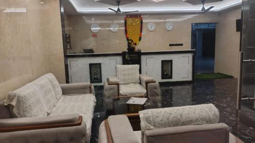 a room with couches and chairs and a fireplace at Lakshmi Residency Chottanikkara in Ernakulam