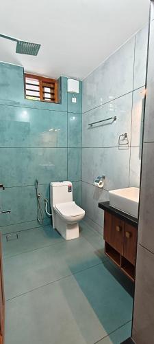 a bathroom with a toilet and a sink at Dr Indulekhas Ayurvedic Wellness & Rejuvenation in Tellicherry