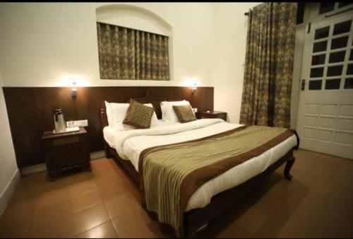 a hotel room with a large bed and a window at The Byke Heritage Resort - Matheran in Matheran