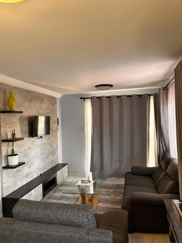 a living room with a couch and a table at Sandton Serenity Escape Cottage in Johannesburg