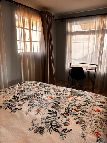 a bedroom with a bed with a floral bedspread at Sandton Serenity Escape Cottage in Johannesburg