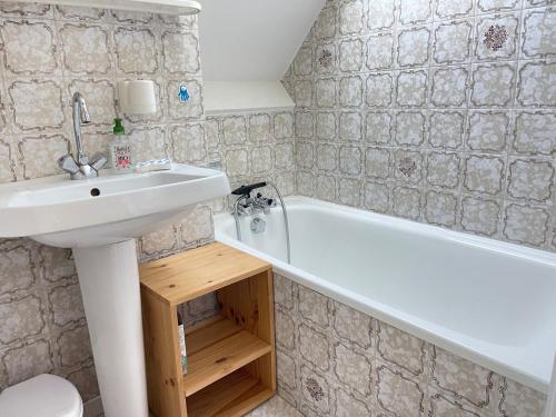 une salle de bain avec un lavabo et une baignoire dans l'établissement Les Galiotes - Maison à Carnac proche plage, à Carnac