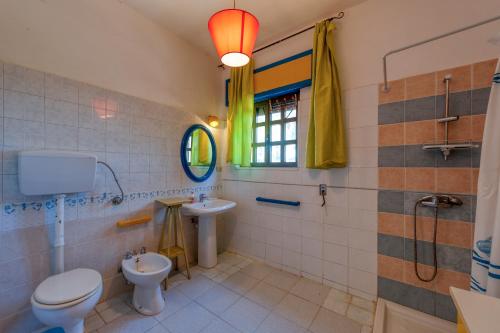a bathroom with a toilet and a sink and a window at Sprocketlandia in Frigole