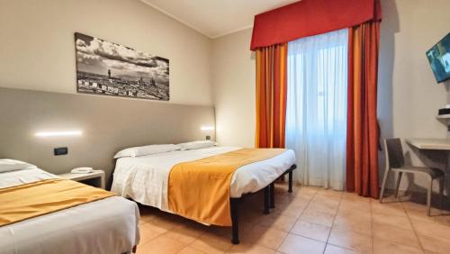 a hotel room with two beds and a desk at Valmarina in Calenzano