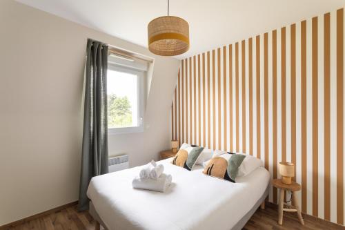 une chambre avec un grand lit blanc et une fenêtre dans l'établissement Kerlibri - 15min à Pied de la Plage, à Dinard