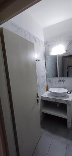 a white bathroom with a sink and a mirror at Villa Kavourakia in Kolios