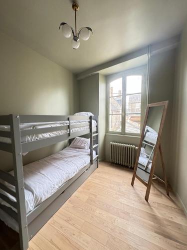 une chambre avec deux lits superposés et une fenêtre dans l'établissement Maison de Beaugency centre boîte à clefs vélos dans la maison, à Beaugency