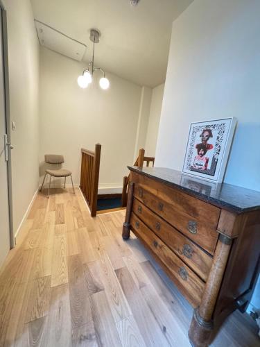 Cette chambre dispose d'une commode en bois avec une photo. dans l'établissement Maison de Beaugency centre boîte à clefs vélos dans la maison, à Beaugency