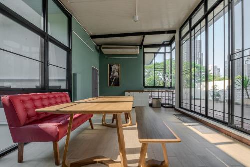 a living room with a wooden table and a red chair at Sukumvit Pool Villa 5BR 5-7min-walk to Thonglor Sky train in Klong Toi