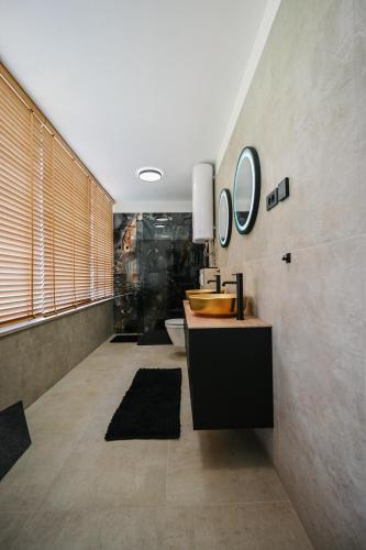 a bathroom with a sink and mirrors on the wall at Petra Hills Majestic in Opatija