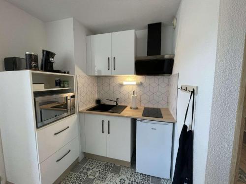 - une petite cuisine avec des placards blancs et un comptoir dans l'établissement NP190-C330 Appartement 2 pièces, Narbonne Plage, à Narbonne-Plage
