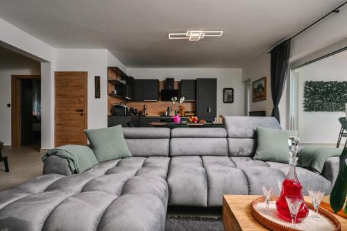 a living room with a large couch and a kitchen at Petra Hills Majestic in Opatija