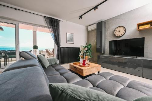 a living room with a large couch and a tv at Petra Hills Majestic in Opatija