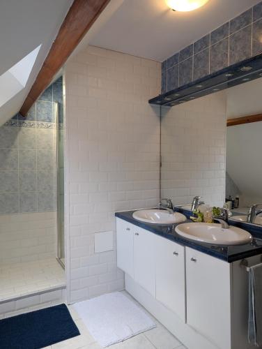 une salle de bain avec deux lavabos et une douche dans l'établissement 3 Chambres-Disneyland Paris, à Saint-Thibault-des-Vignes