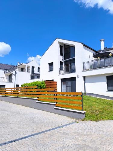 a row of wooden benches in front of a building at Blackbird Boutique Apartment in Keszthely