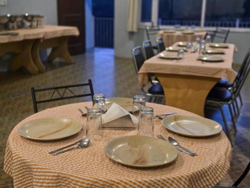 a table with plates and utensils on top at Hotel City Gold - Hotel in Dharamshala in Dharmsala
