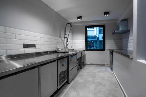 a large kitchen with stainless steel counters and a window at Smart and Simple Hotel Karakoy in Istanbul