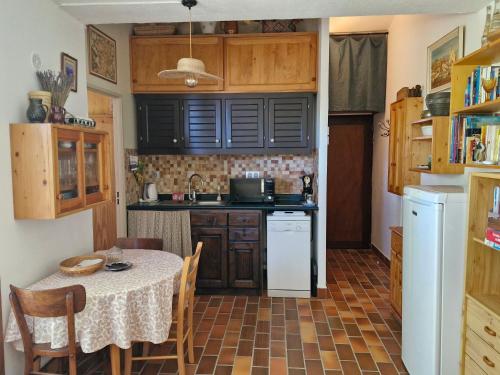 une petite cuisine avec une table et une table et des chaises dans l'établissement Maisonnette de charme au pied du Mont Ventoux !, à Bédoin