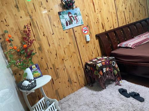 a room with a bed and a table with shoes at ROSIE HOMESTAY Hà Giang in Ha Giang
