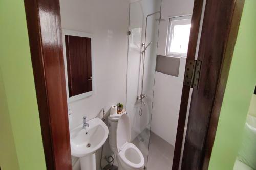 a bathroom with a toilet and a sink at Manuela Suites Puerto Princesa near Airport in Puerto Princesa City