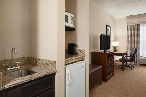 a hotel room with a sink and a kitchen at Country Inn & Suites by Radisson, Anderson, SC in Anderson