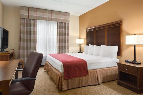 a hotel room with a bed and a desk and a chair at Country Inn & Suites by Radisson, Anderson, SC in Anderson