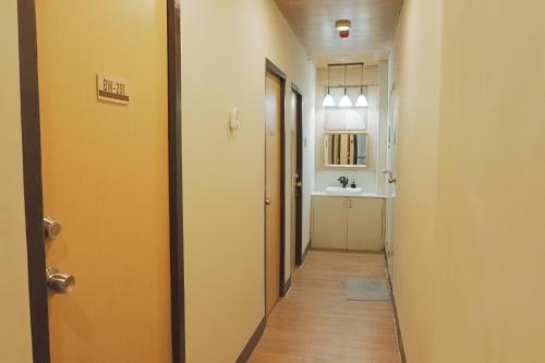 a hallway with a door and a sink at Brightwood Hotel & Residences in Manila
