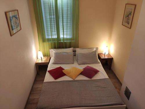 ein Schlafzimmer mit einem Bett mit zwei Kissen und einem Fenster in der Unterkunft Apartmani TOPLA - Zlokovic - apartman A3 i apartman A4 in Topla