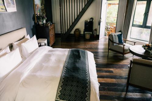 a bedroom with a white bed and a staircase at Nuuk Taal Lake in Laurel