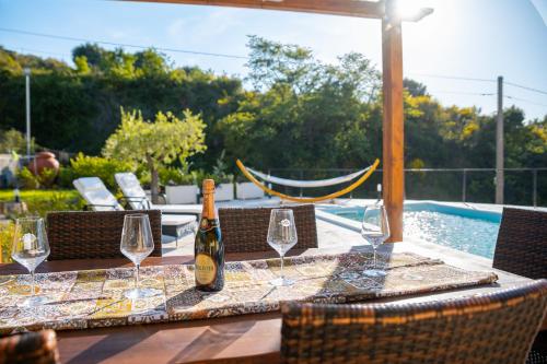 a bottle of wine sitting on a table with wine glasses at Villa Grace with private pool in Ascea