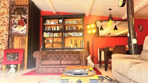 a living room with a couch and a table and book shelf at Havre de paix Avignon avec Jacuzzi & Sauna in Avignon