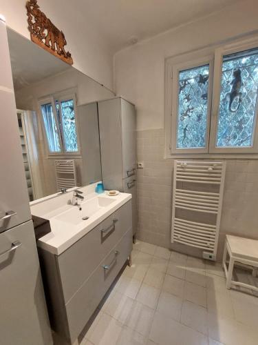 une salle de bain blanche avec un lavabo et un miroir dans l'établissement Domica, à Grasse