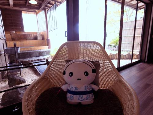 a teddy bear sitting in a rattan chair at Shin Kadoya in Atami