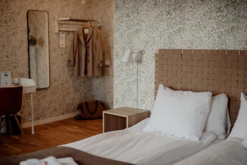 a bedroom with a bed and a coat hanging on the wall at Hotell & Bistro Rödesund in Karlsborg