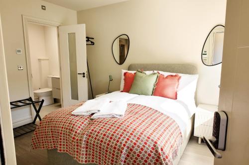 a bedroom with a bed with red and green pillows at George Apartments in Broadway