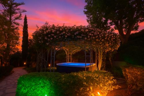 a garden with a gazebo with a blue pool at Villa Small Paradise private pool, jacuzzi, BBQ, complete privacy in Ialyssos