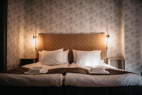 a bedroom with a large bed with white sheets and pillows at Hotell & Bistro Rödesund in Karlsborg