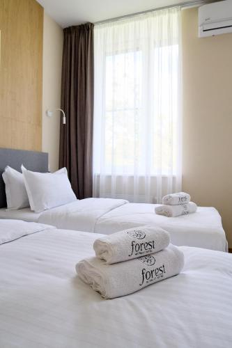 two beds in a hotel room with towels on them at Forest Retreat Center in Kyiv