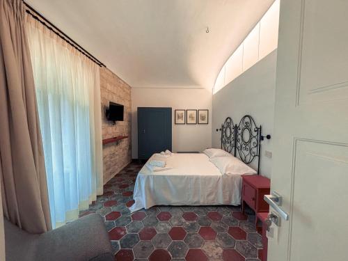 a bedroom with a white bed and a window at Spighe e Fenicotteri in Modica