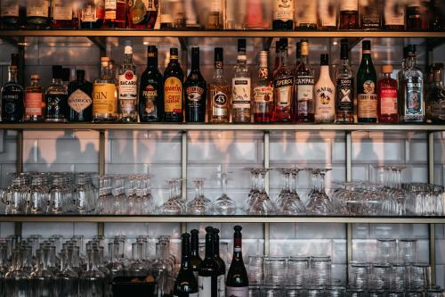 a shelf full of glasses and bottles of alcohol at Hotell & Bistro Rödesund in Karlsborg