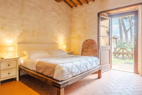 a bedroom with a bed and a large window at Casone Ugolino in Donoratico